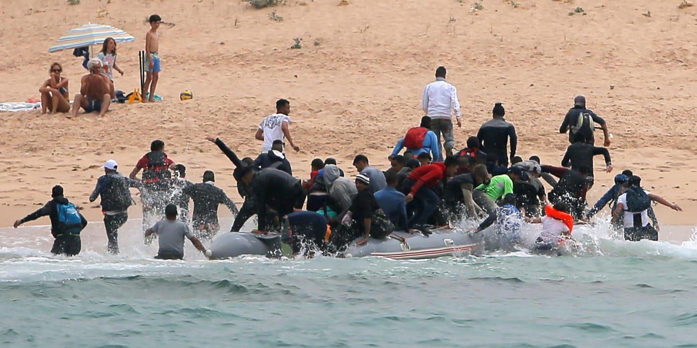 Cañuelostranden i sydspanska Tarifa i fredags: Häpna badgäster betraktar en landstigning av migranter.