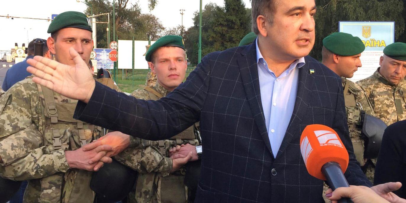 Georgiens expresident Micheil Saakasjvili talar till media medan gränsvakter försöker hindra honom att ta sig in i Ukraina.