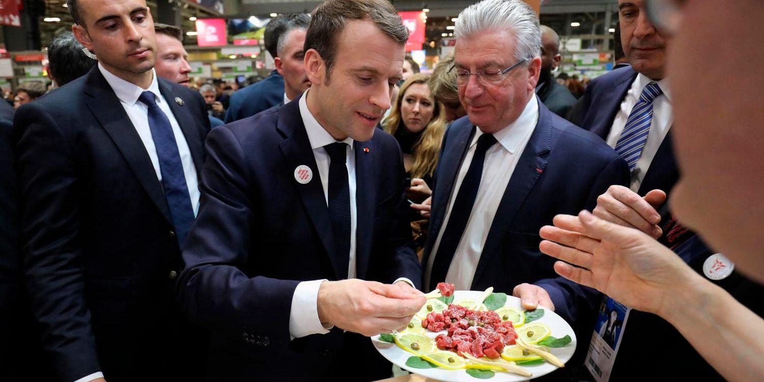 Emmanuel Macron låter sig väl smaka under en jordbruksmässa i Paris den gångna helgen.