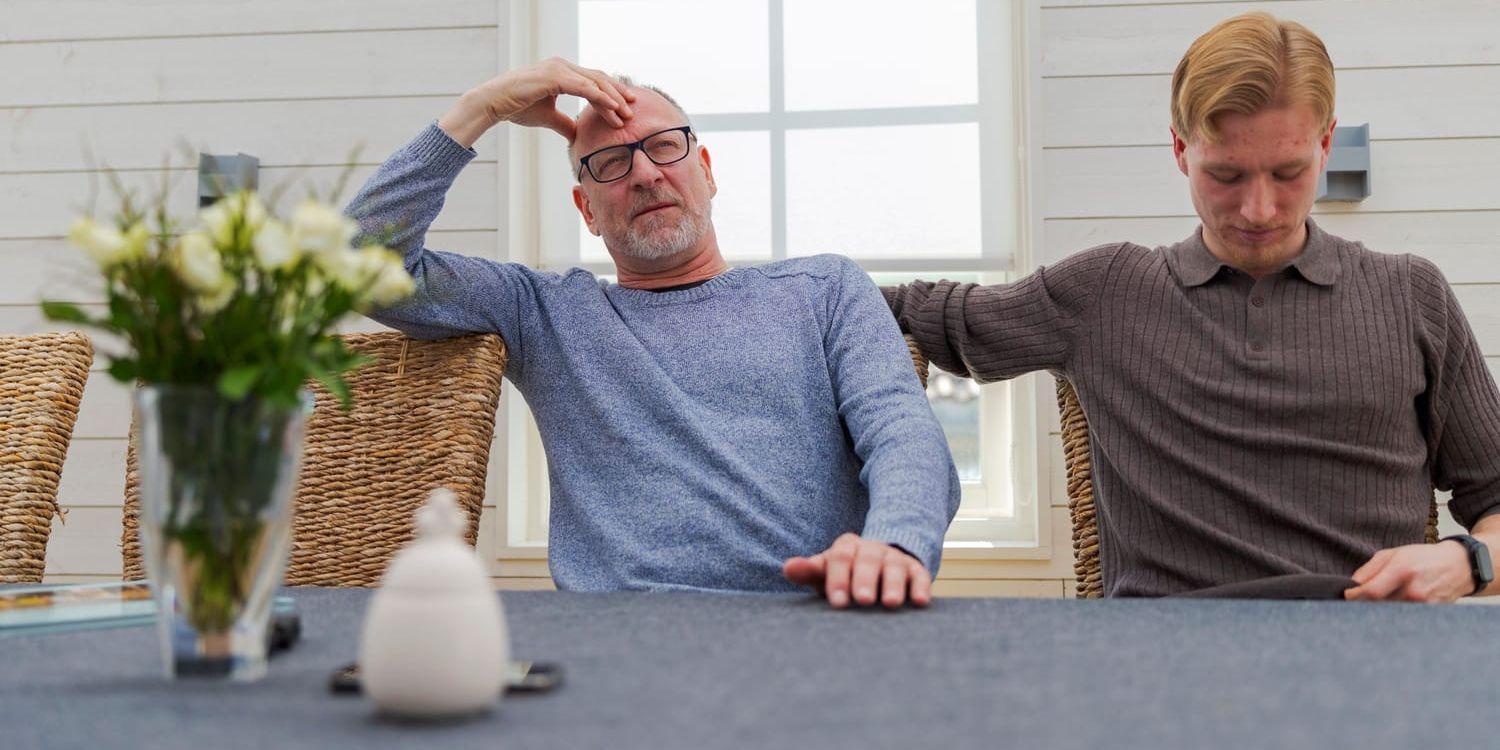 En pappa och hans son sitter vid ett bord.