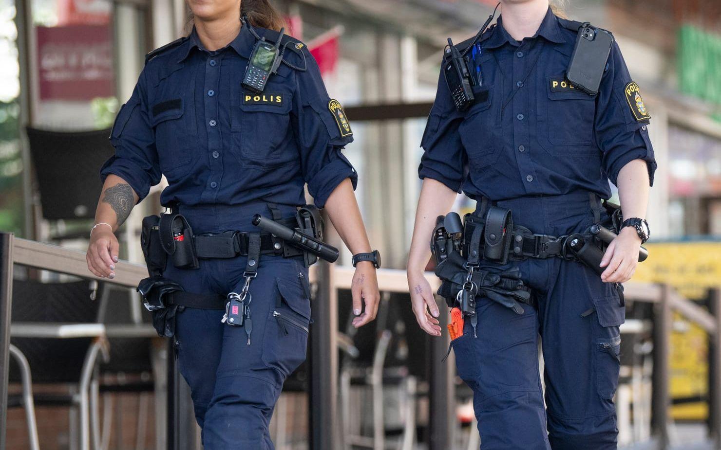 Två poliser patrullerar till fots i Stockholmsförorten Hässelby. Arkivbild.