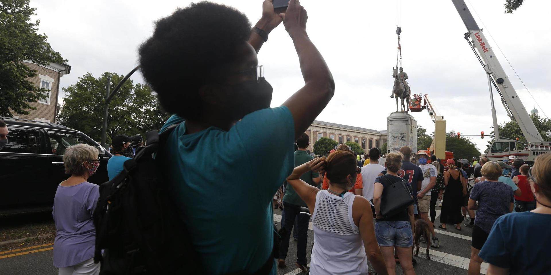 Demonstranter tittar på när statyn av sydstatsgeneralen Thomas 'Stonewall' Jackson rivs i Richmond, Virginia.
