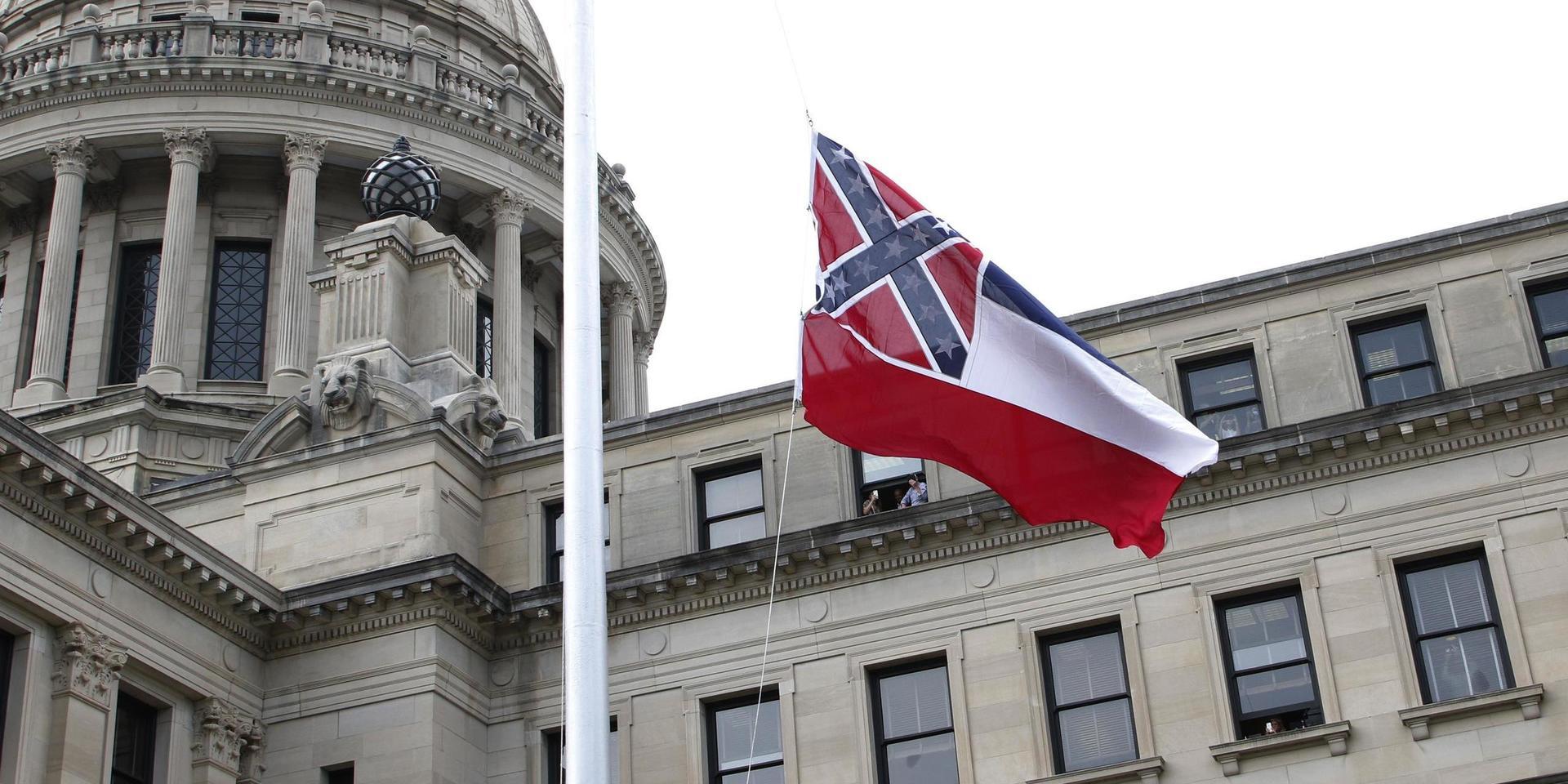 Mississippis delstatsflagga med en sydstatsflagga inkluderad vajar i vinden för sista gången vid kongressbyggnaden i Jackson.