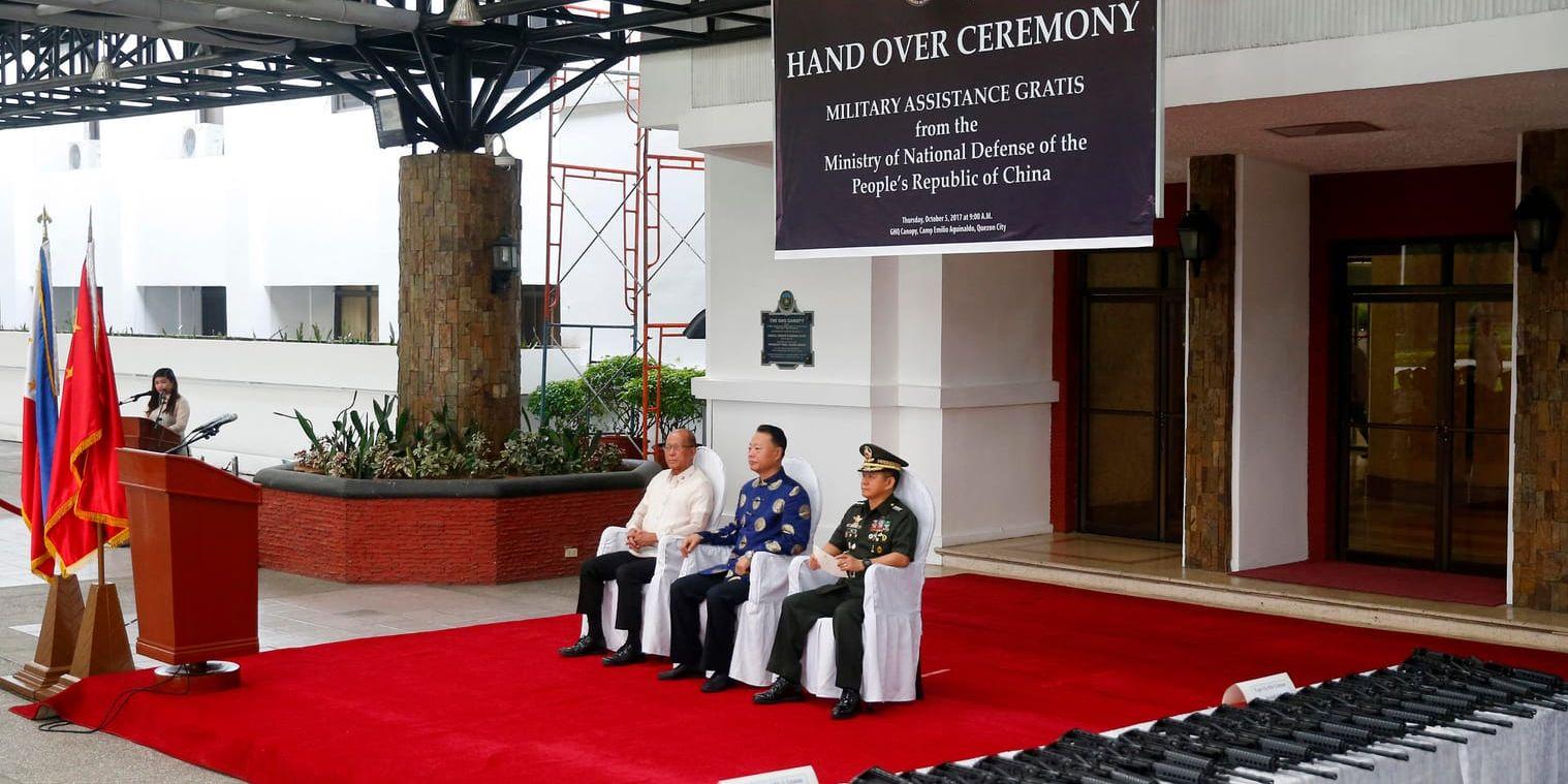 Kinas ambassadör Zhao Jianhua och Filippinernas försvarsminister Delfin Lorenzana under den felaktiga loggan.