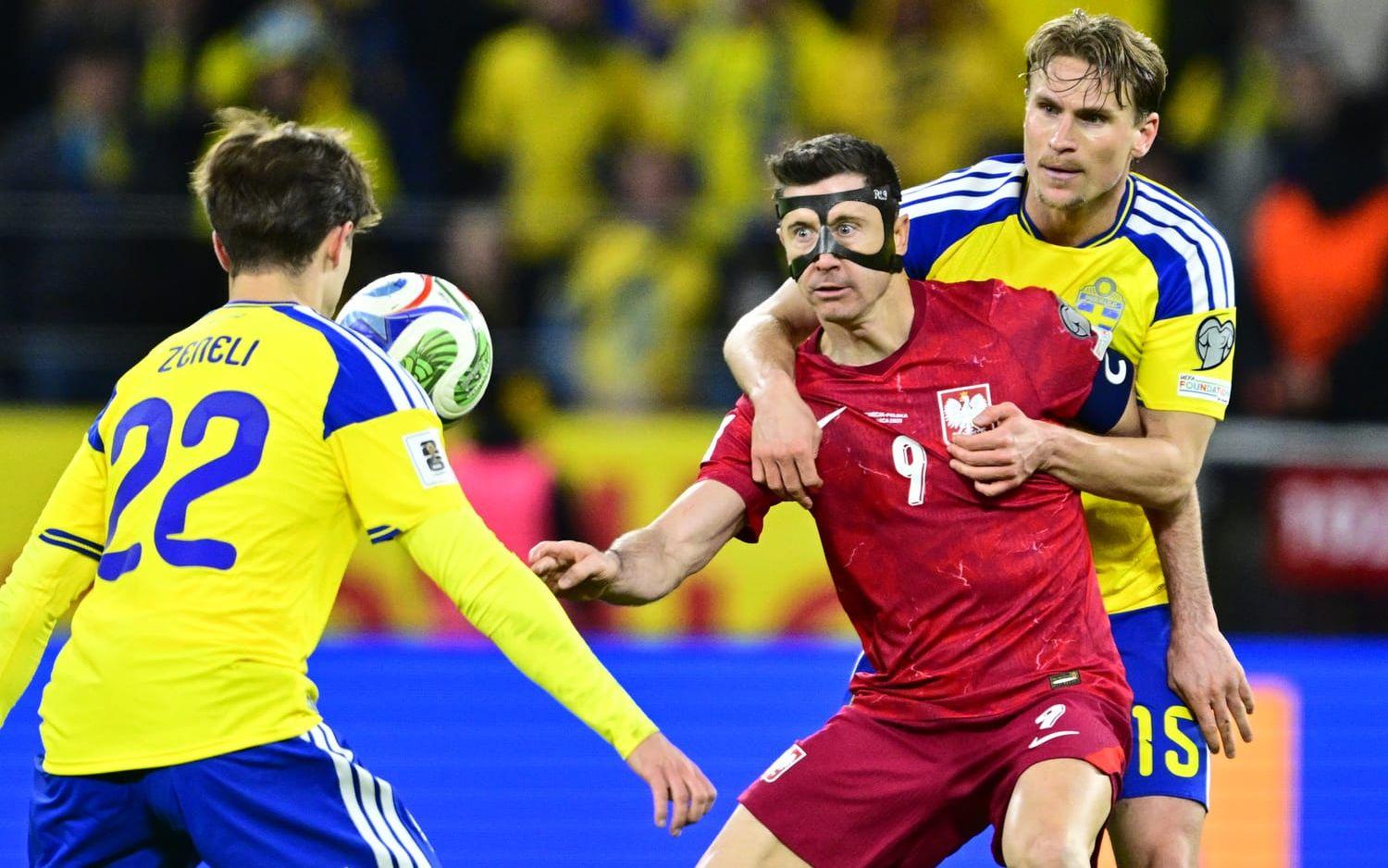 Carl Starfelt, till höger, i kamp om bollen med Polens Robert Lewandowski i VM-kvalets playoff-final.