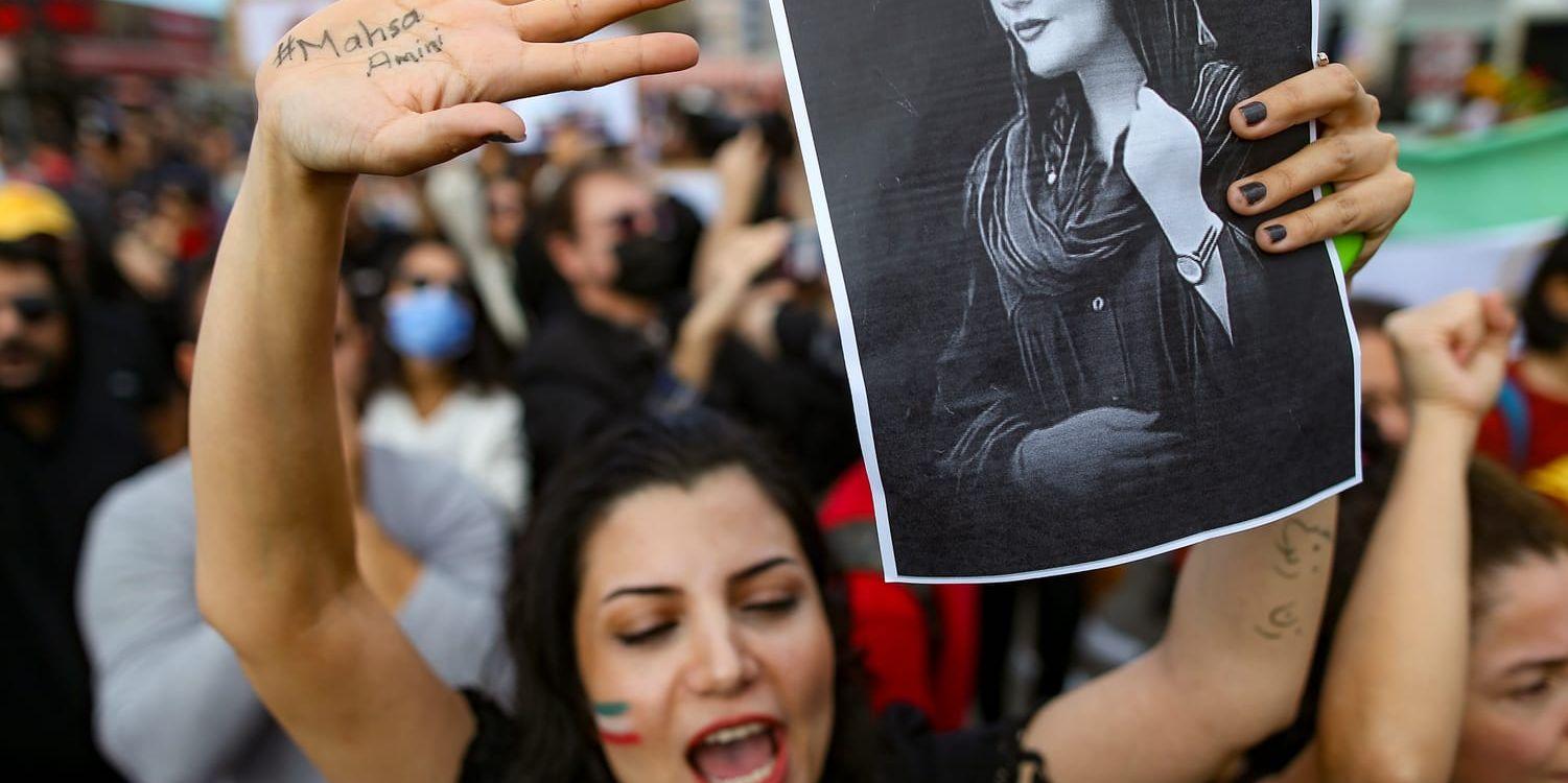 En kvinna håller upp ett fotografi av Mahsa Amini under protester i Turkiet mot den iranska regimen.