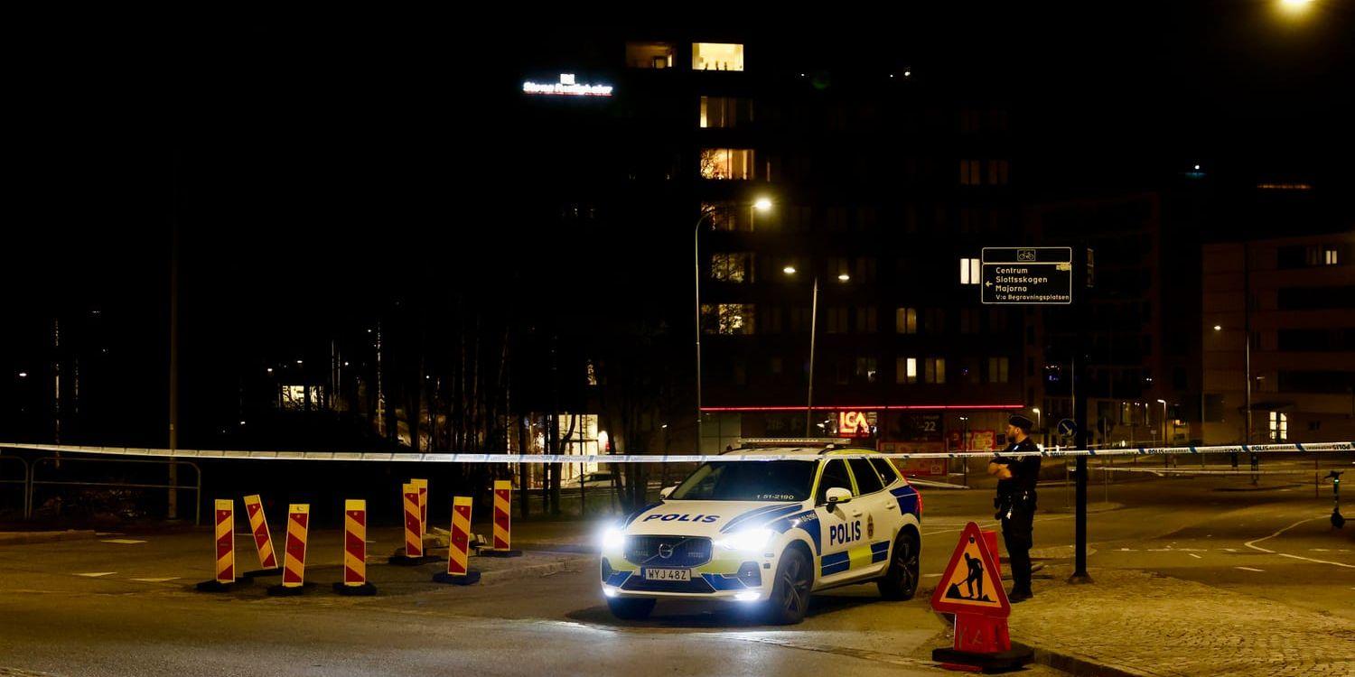 Polisbil bakom avspärrningsband på gata.