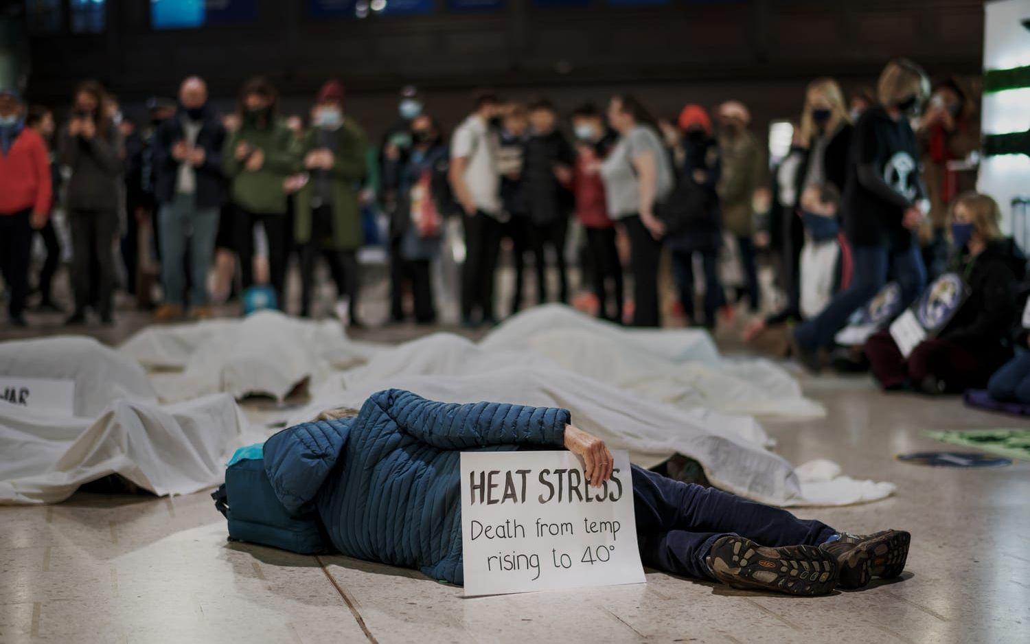"Heat stress, death from temp rising to 40°" står det på en av skylltarna när Extinction rebellion har en aktion vid Glasgow Central Station.