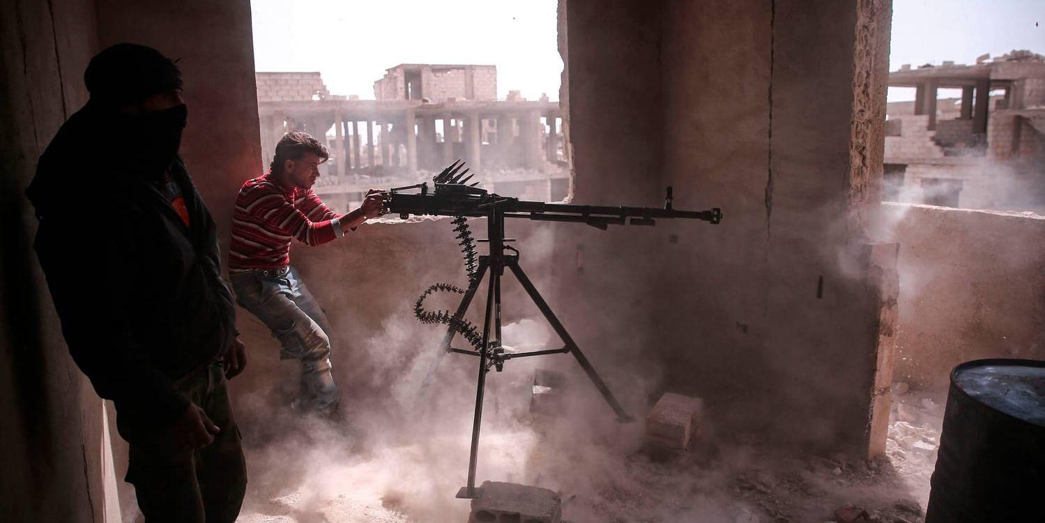 En oppositionell soldat avlossar en kulspruta i de östra utkanterna av Damaskus.