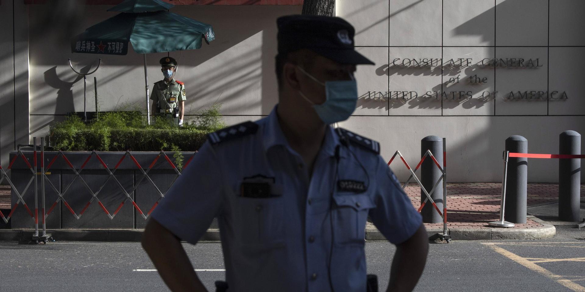 Kinesisk säkerhetspersonal utanför det amerikanska konsulatet i den kinesiska staden Chengdu. Under fredagen beordrade Kina att USA skulle stänga ned konsulatet efter att USA beordrat Kina att stänga sitt konsulat tidigare i veckan.