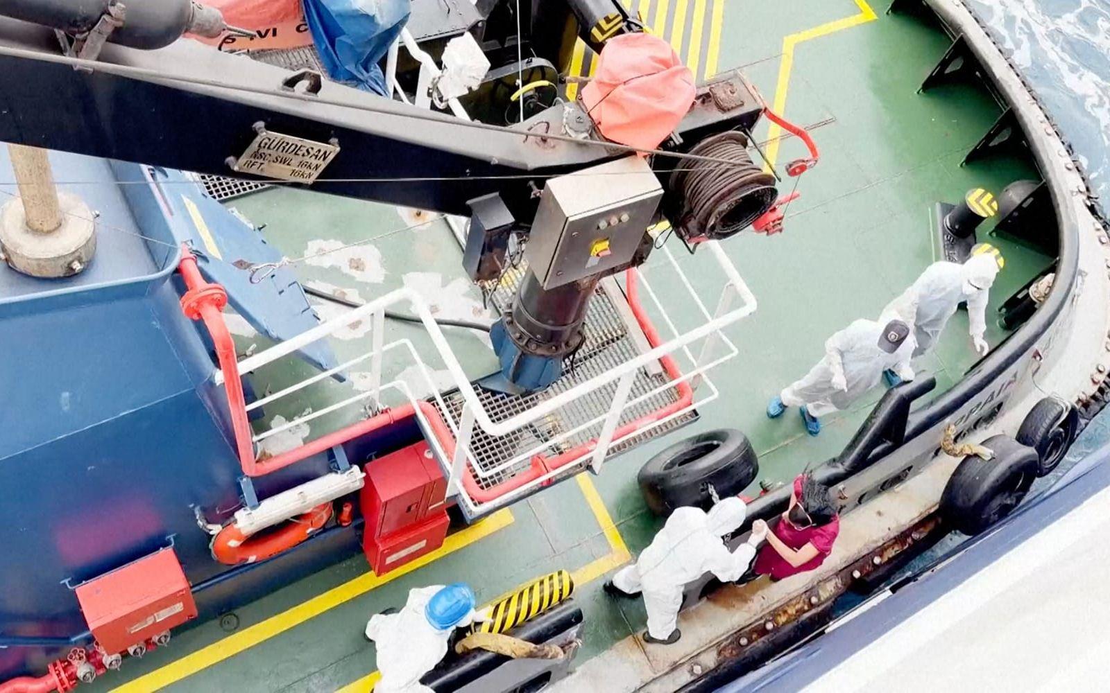 Vårdarbetare i skyddsutrustning hjälper en kvinna på MV Hondius i måndags.