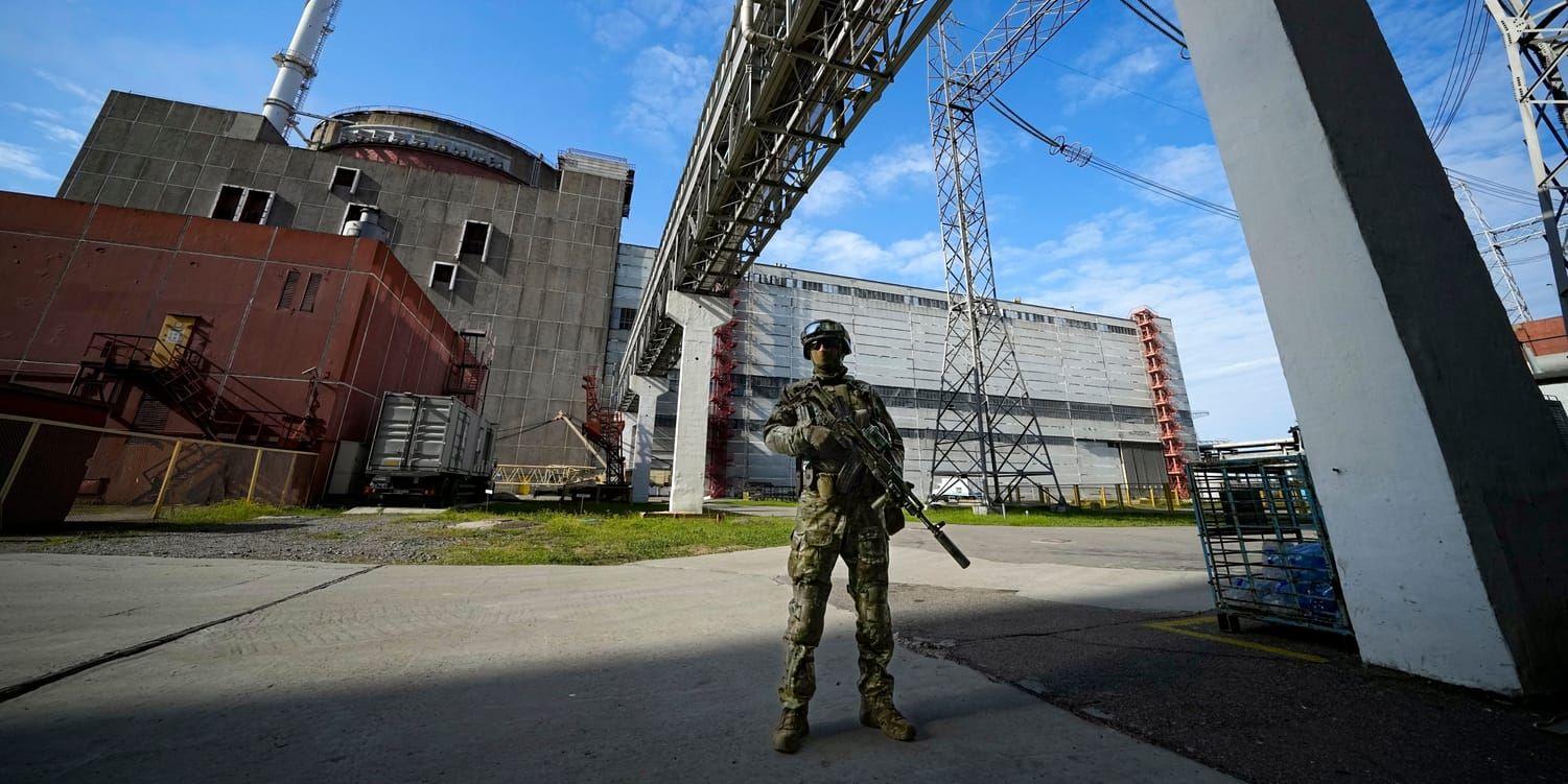 En rysk soldat står vakt vid kärnkraftverket i Zaporizjzja. Kärnkraftverket har skakats av ny beskjutning under helgen.