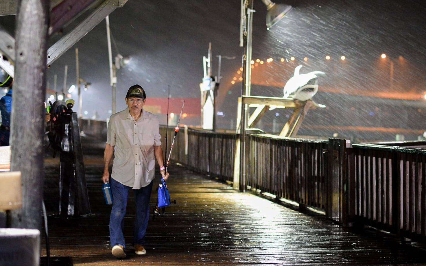 Rogelio Ortiz tar sig av Pirate's landing fishing pier i skyfallet från orkanen Harvey. Bild: TT
