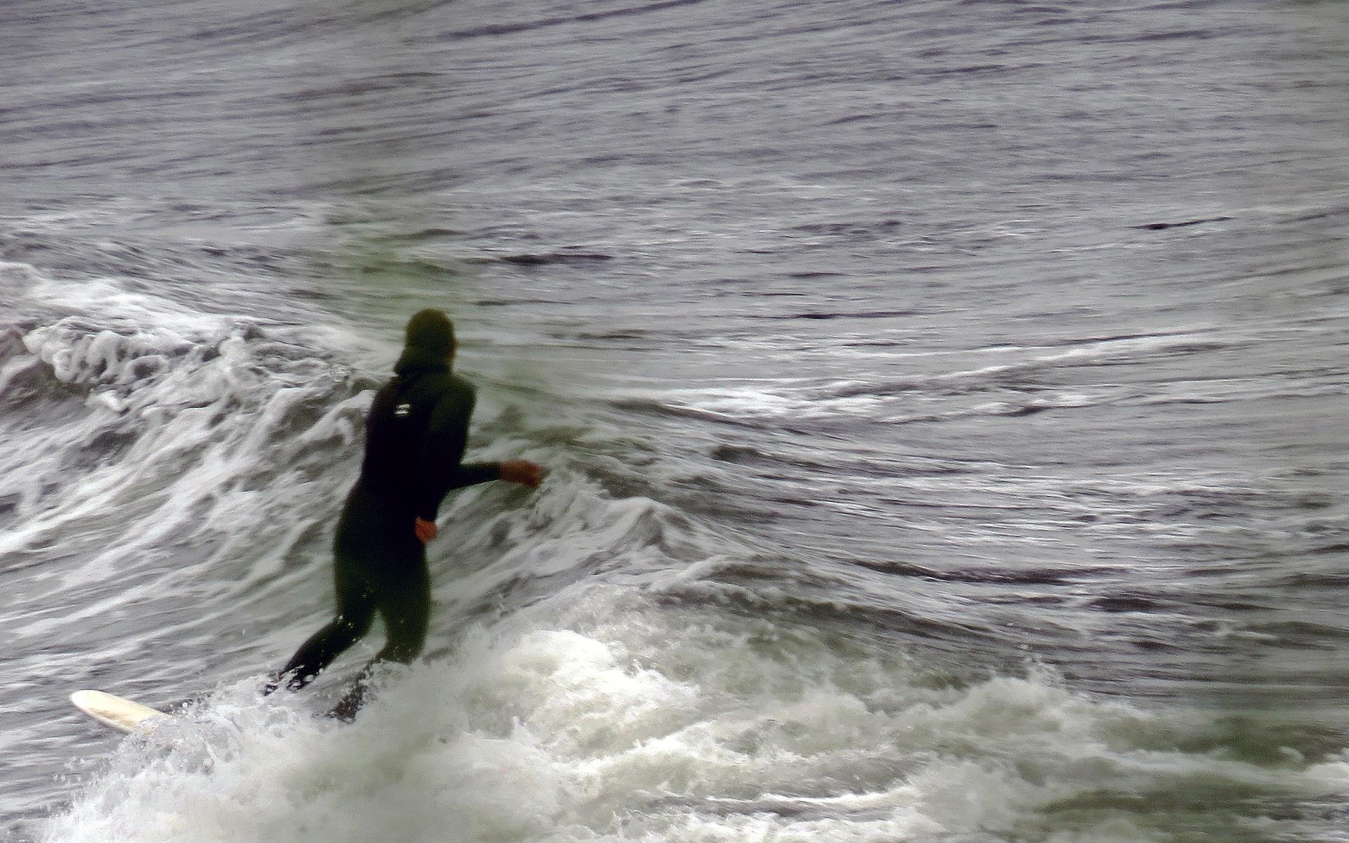 Surfare med stolt hållning uppe på vågen. 