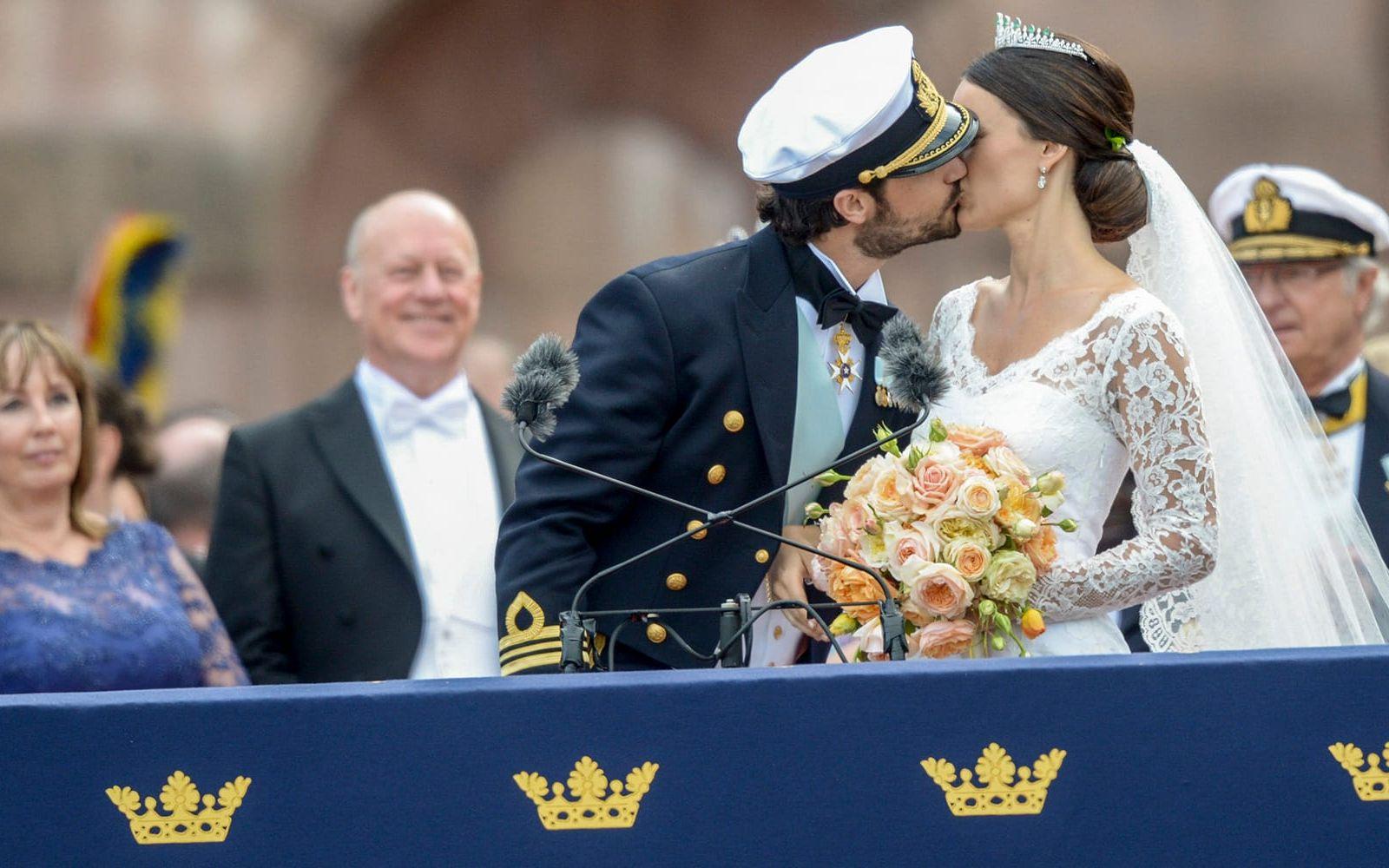 Prins Carl Philip och prinsessan Sofia kysser varandra då de tar emot allmänhetens lyckönskningar på Logården efter bröllopet. Foto: Fredrik Sandberg/TT
