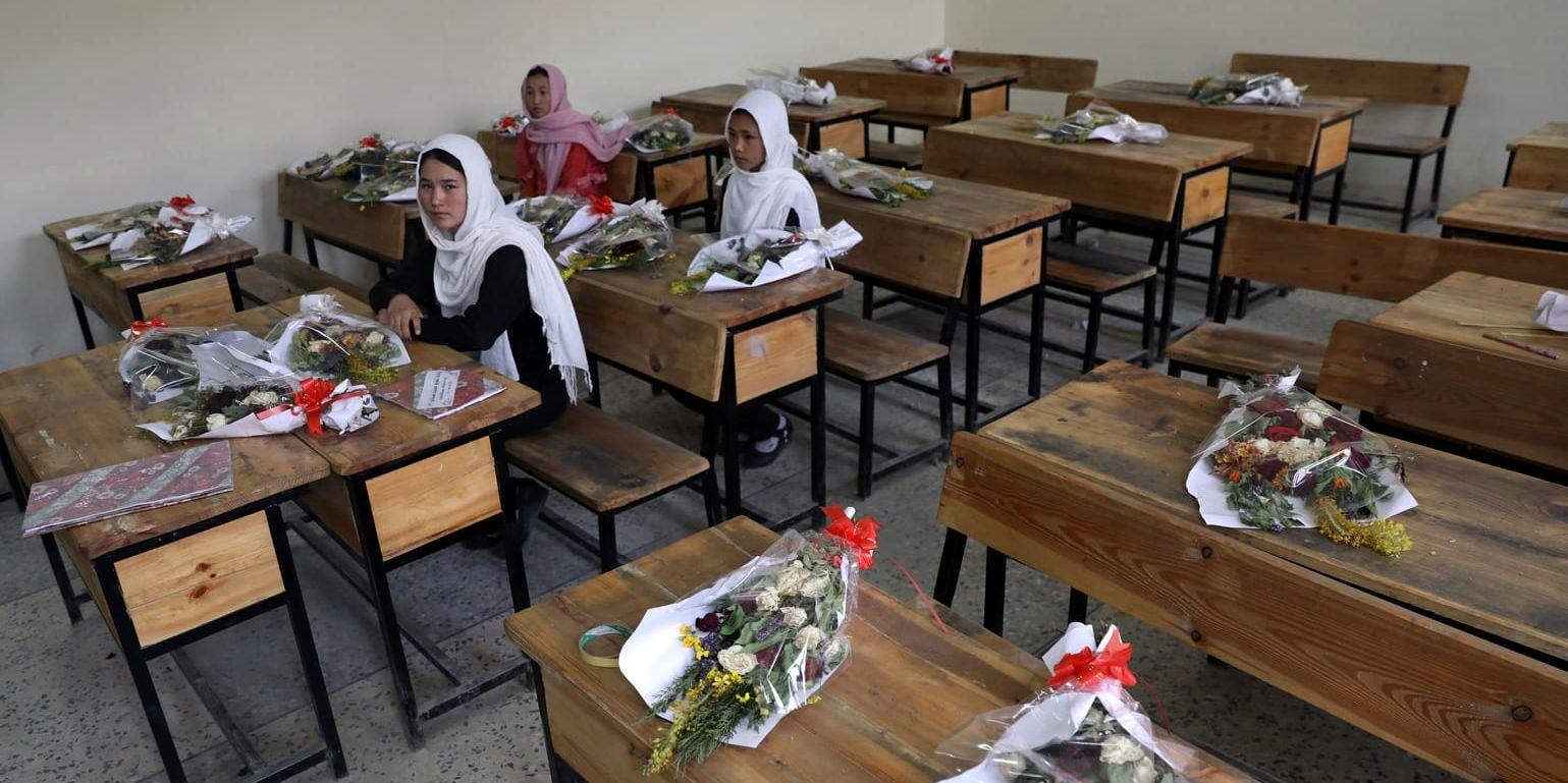 Flickor i en skola i Afghanistans huvudstad Kabul med blommor på de bänkar där klasskamrater som dödats suttit. Arkivbild.