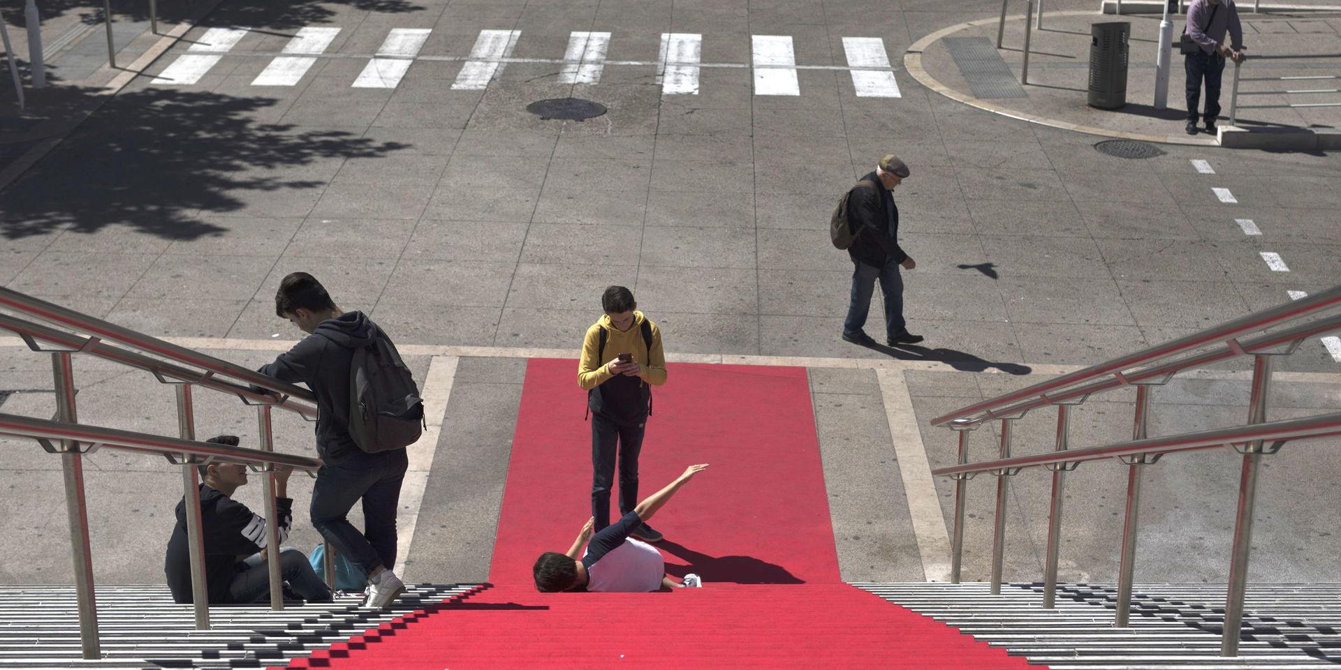 En turist tar en bild på röda mattan framför Cannes tågstation under årets filmfestival.