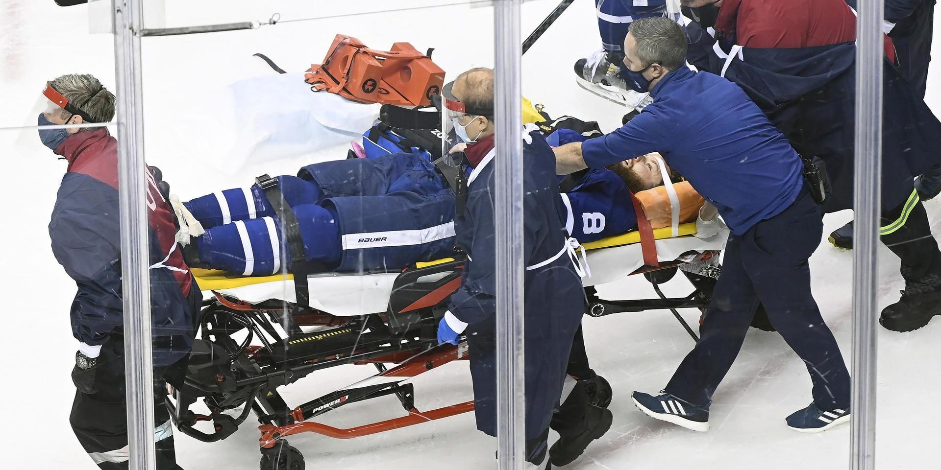 Toronto Maple Leafs back Jake Muzzin förs ut på bår under nattens NHL-match.