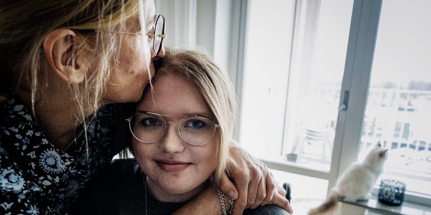 Mamma håller om dotter i 30-årsåldern som sitter i rullstol