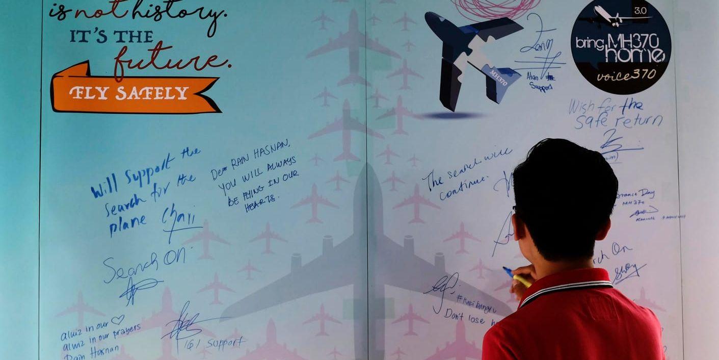 En man skriver en kondoleans på minnesdagen i mars i år av MH370:s försvinnande i Kuala Lumpur i Malaysia. Arkivbild.