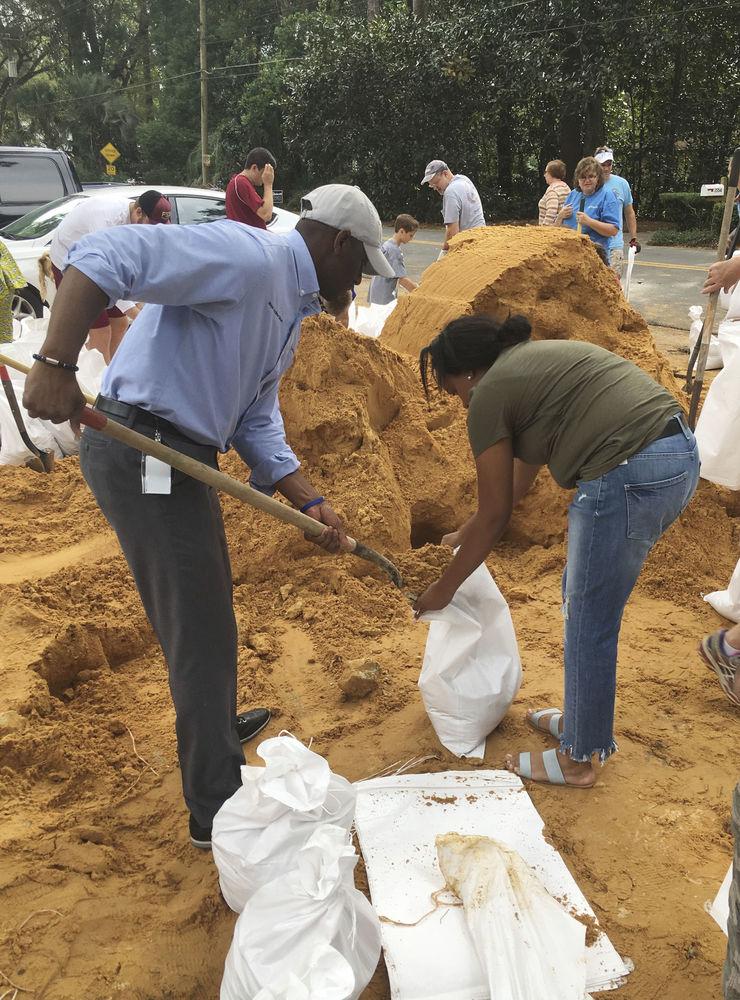 Tallahassees borgmästare och nu även guvernörskandidat Andrew Gillum, till vänster, hjälper Eboni Sipling fylla sandsäckar i Tallahassee, Florida.