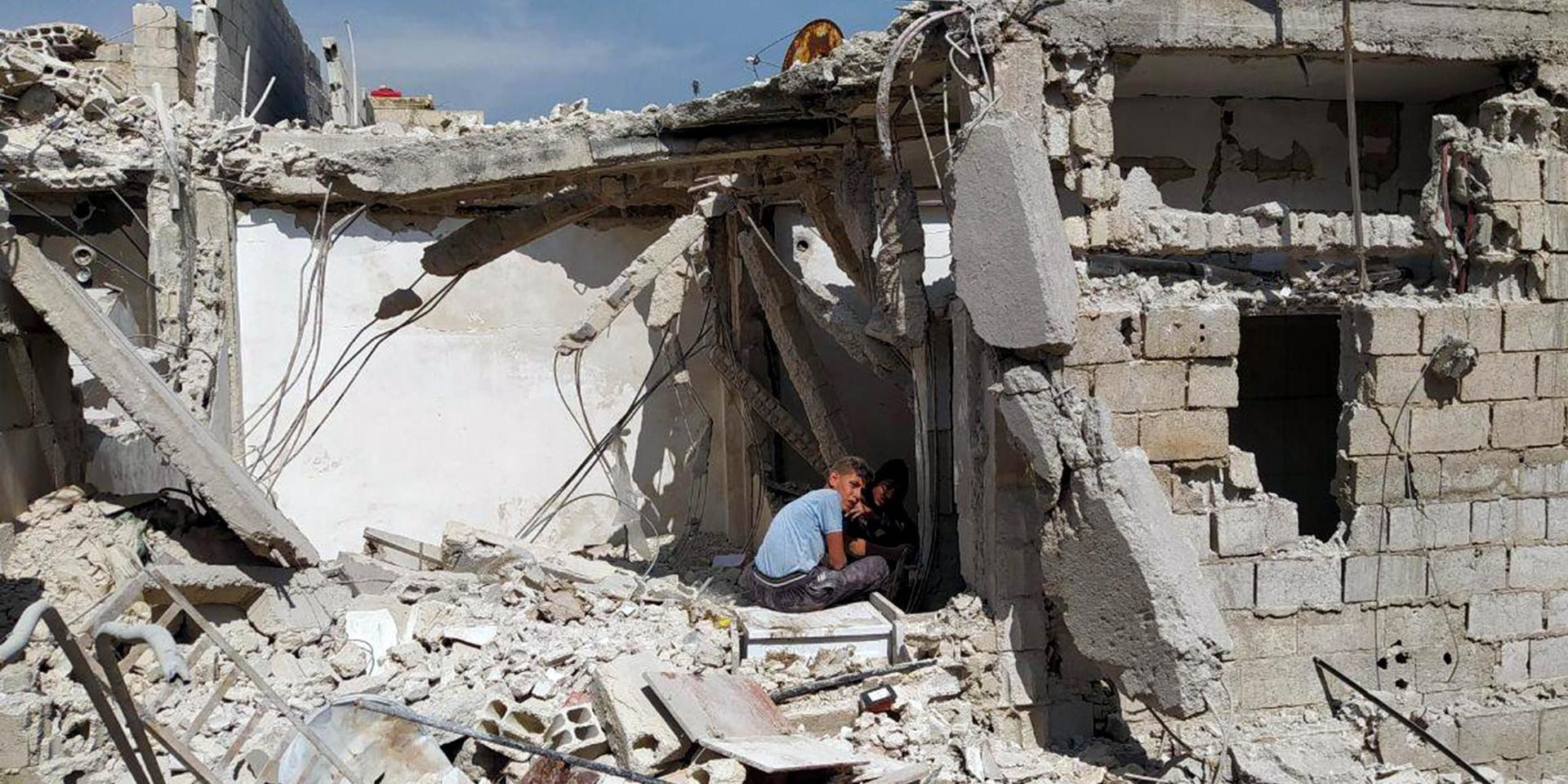 Pojkar leker i en ruin i en förort till det krigshärjade Syriens huvudstad Damaskus. 