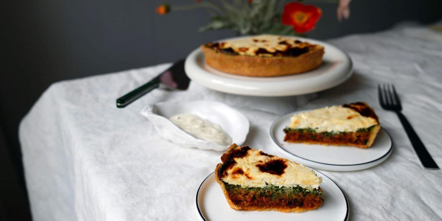 Tacopaj uppdukad på vit duk med blommor i bakgrunden.