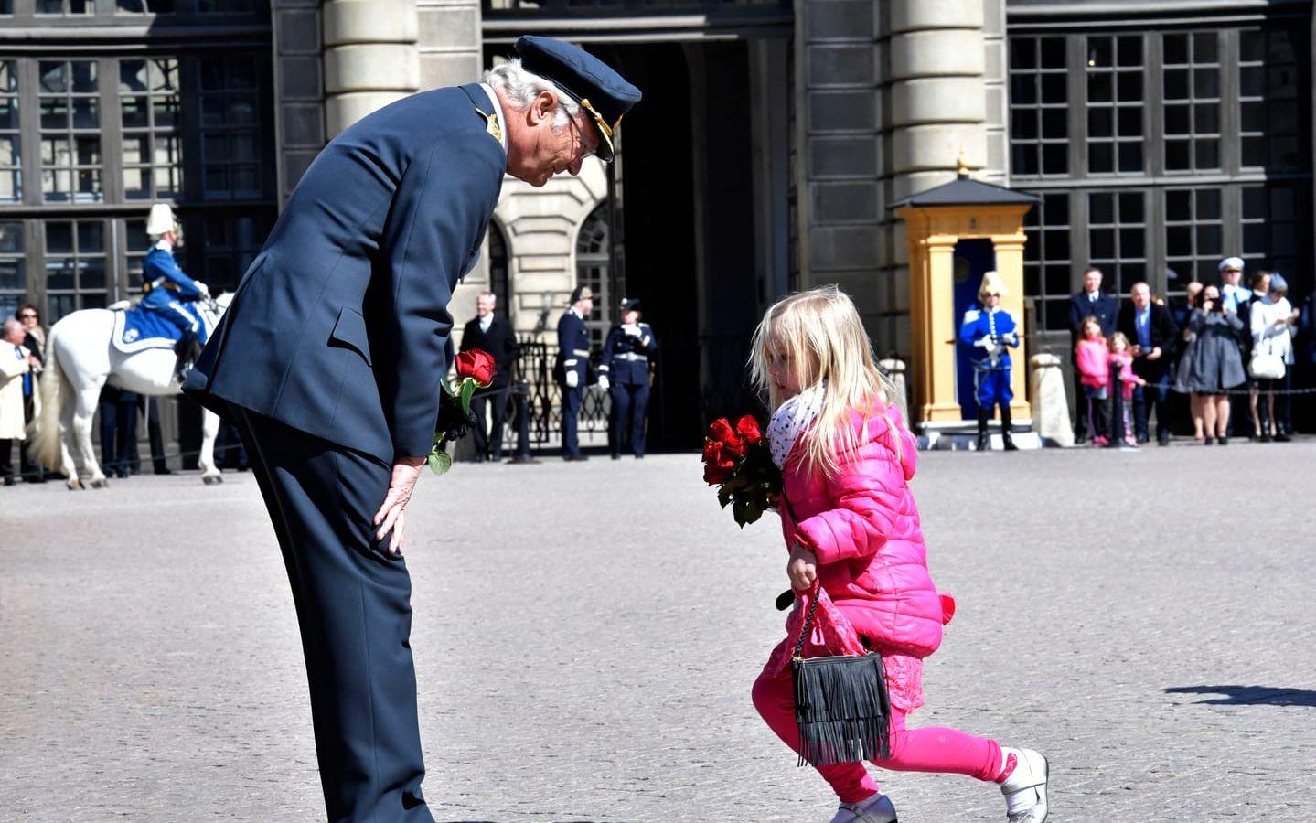 Kung Carl Gustaf tar emot blommor från barn när han firas på sin 71:a födelsedag på yttre borggården på Stockholm slott den 30 april, 2017. Foto: TT