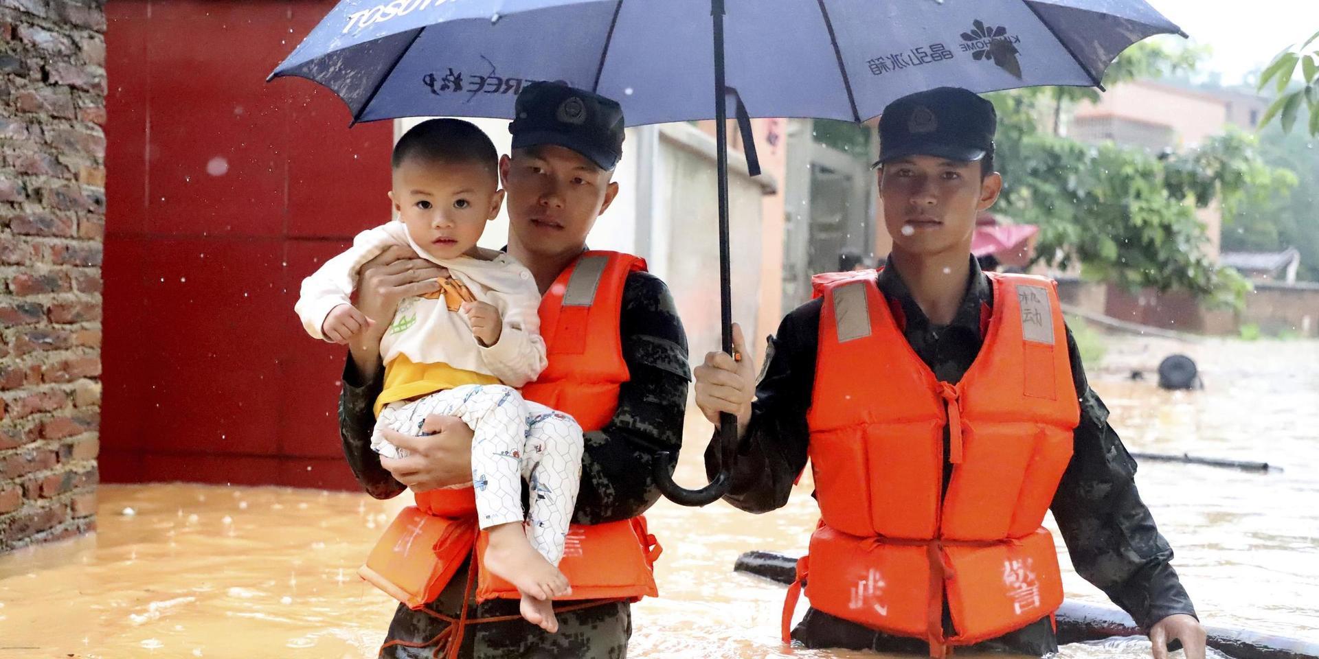 Ett barn evakueras tidigare i veckan i den översvämmade byn Qingyuan i Guangdong-provinsen i södra Kina. 
