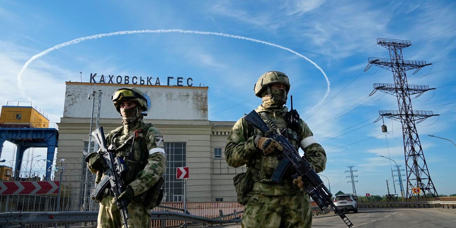 Ryska soldater på vakt vid ingången till Kakhovkas hydroelektriska station vid floden Dnepr i Kherson-regionen i södra Ukraina. Bilden togs i maj. Nu har ukrainska styrkor inlett en motoffensiv i söder. Det ökar spänningen även vid kärnkraftverket i södra Ukraina.