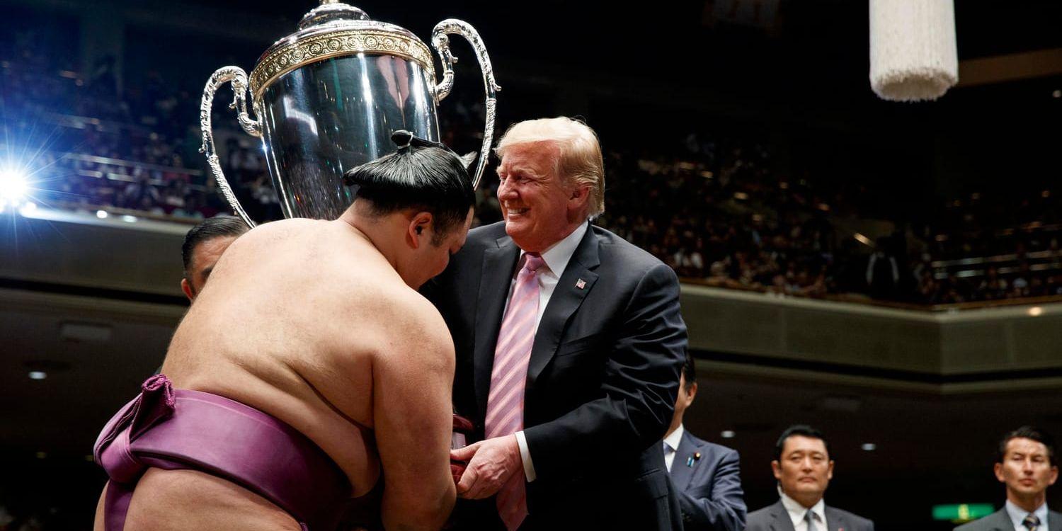 USA:s president Donald Trump överlämnar den specialgjorda presidentpokalen till vinnaren av sumobrottarturneringen Asanoyama på arenan Ryogoku Kokugikan under sitt statsbesök i Japan.