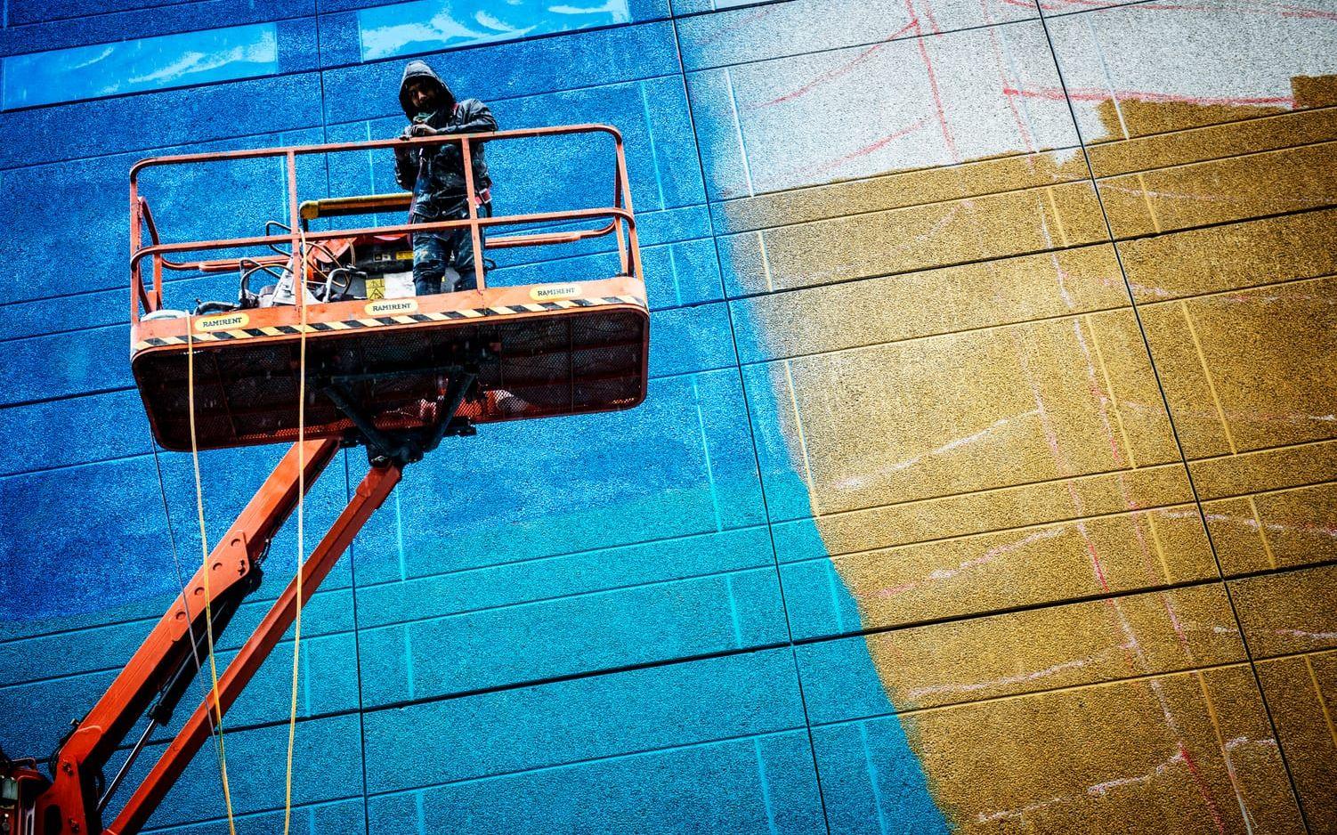 Den mexikanske graffitikonstnären Sens är på plats i Hammarkullen. Både han och Charqui Punk behöver använda skylifts när de målar. Foto: Jenny Ingemarsson.