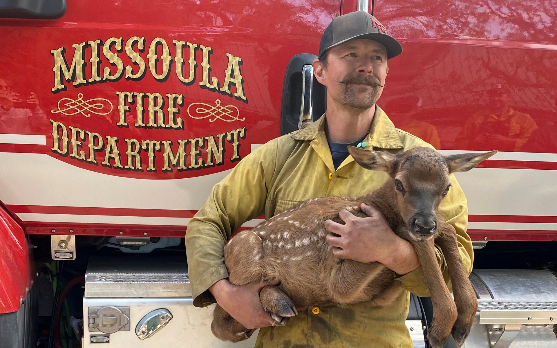 Brandmannen Nate Sink vaggar en nyfödd hjortkalv som han mötte i ett avlägset, eldhärdat område i Sangre de Cristo-bergen nära Mora, New Mexico, lördagen den 21 maj.