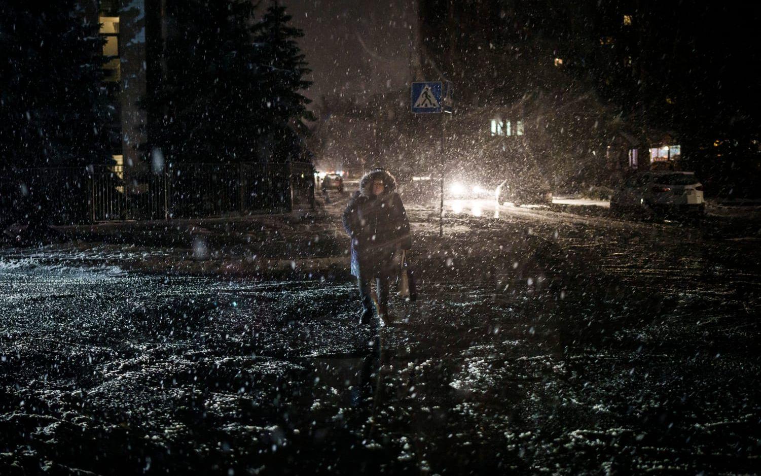 En kvinna korsar en gata i ett strömlöst Kiev i december 2022.