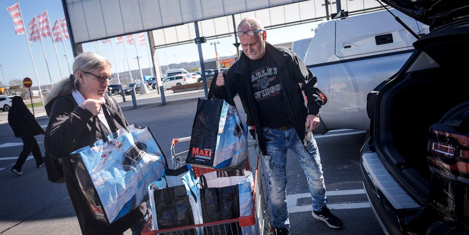 Ett par som packar in sina varor från ett ICA-besök i bilen.