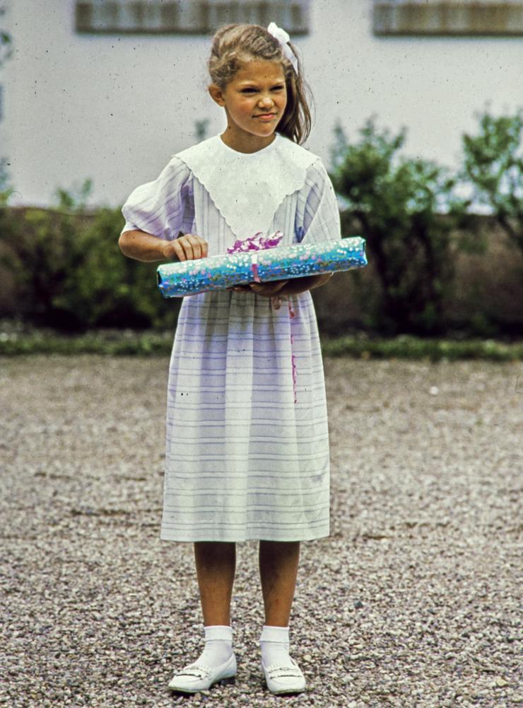 Här firas hon 1987. Födelsedagsbarnet kronprinsessan Victoria med en present  i samband med firandet av Victoriadagen på kungafamiljens sommarresidens. 