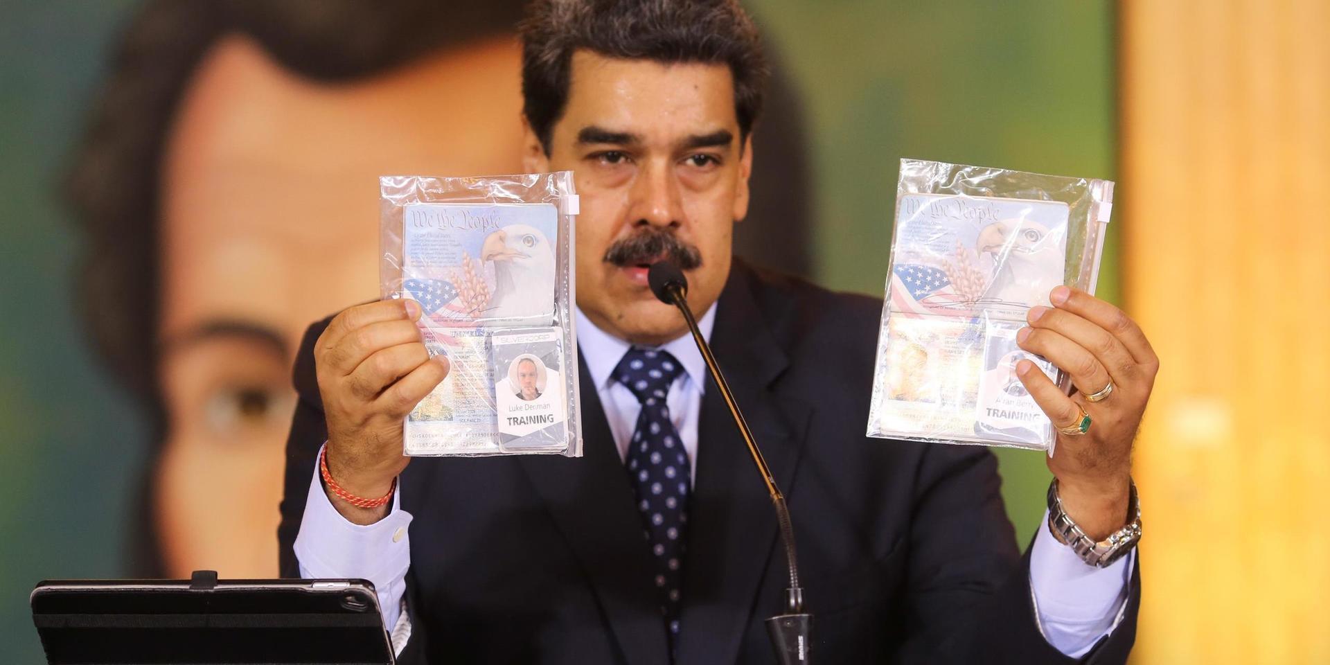 Venezuelas president Nicolás Maduro visar upp de nu dömda amerikanernas identitetshandlingar på en presskonferens i Caracas den 6 maj. Arkivbild.