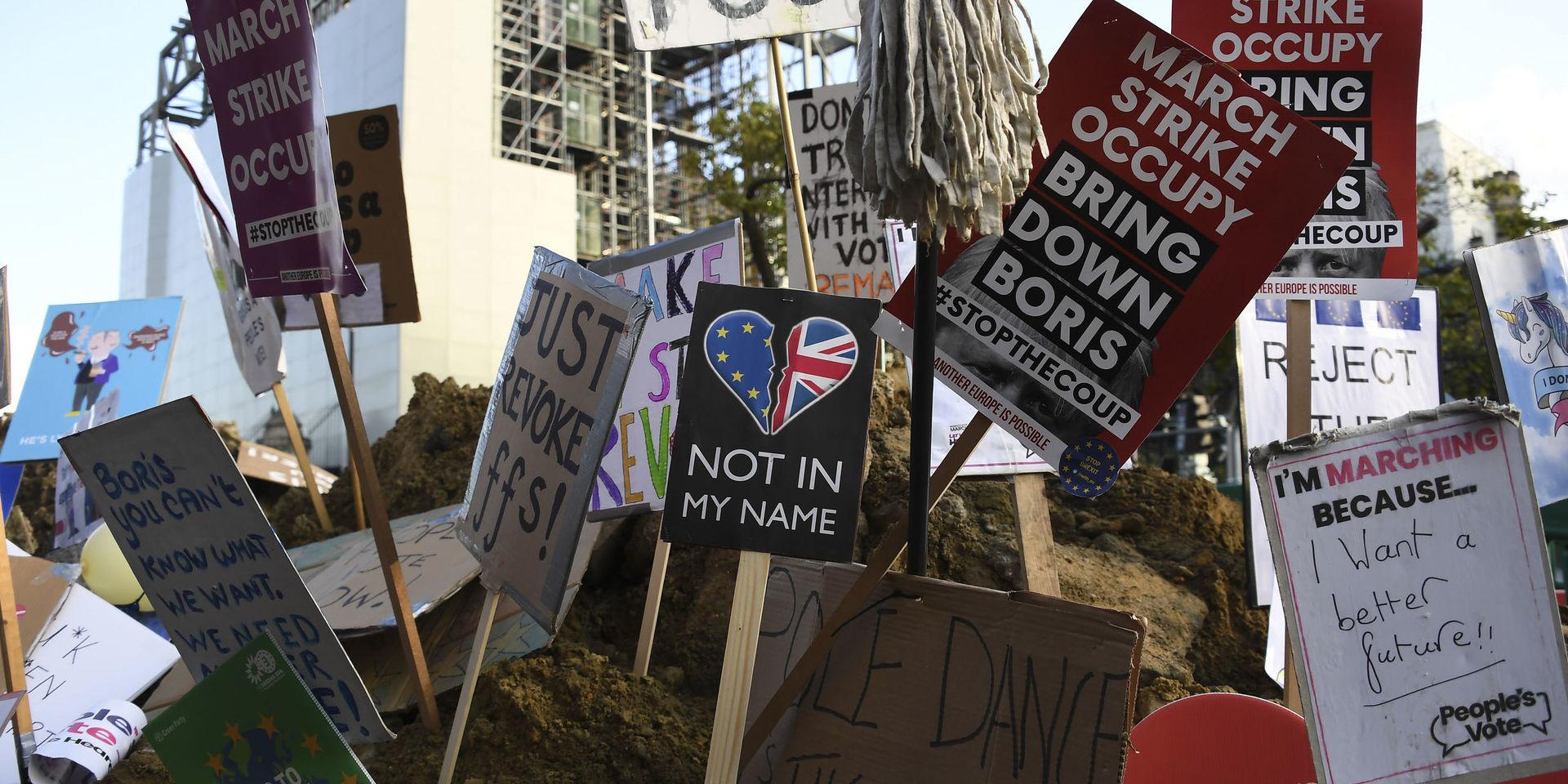 Skyltar med antibrexitbudskap nedstuckna i en hög av jord efter lördagens demonstration i London med krav på en ny folkomröstning. 