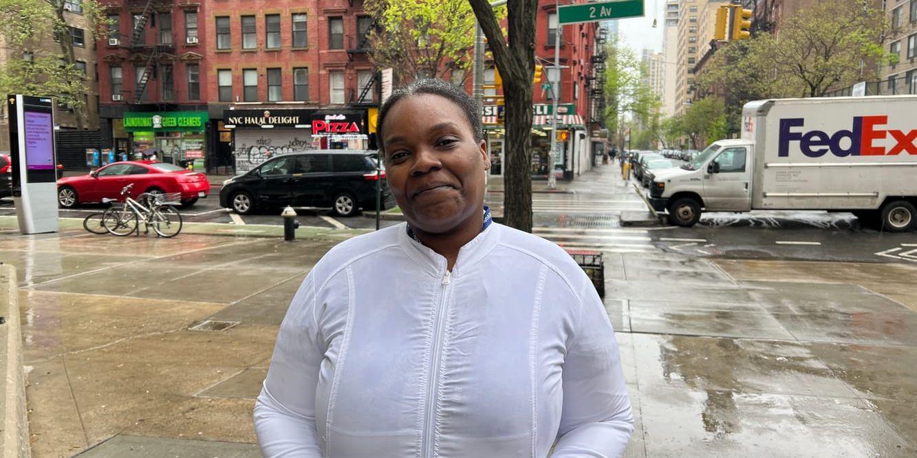 Kvinna i vit jacka i stadsmiljö.