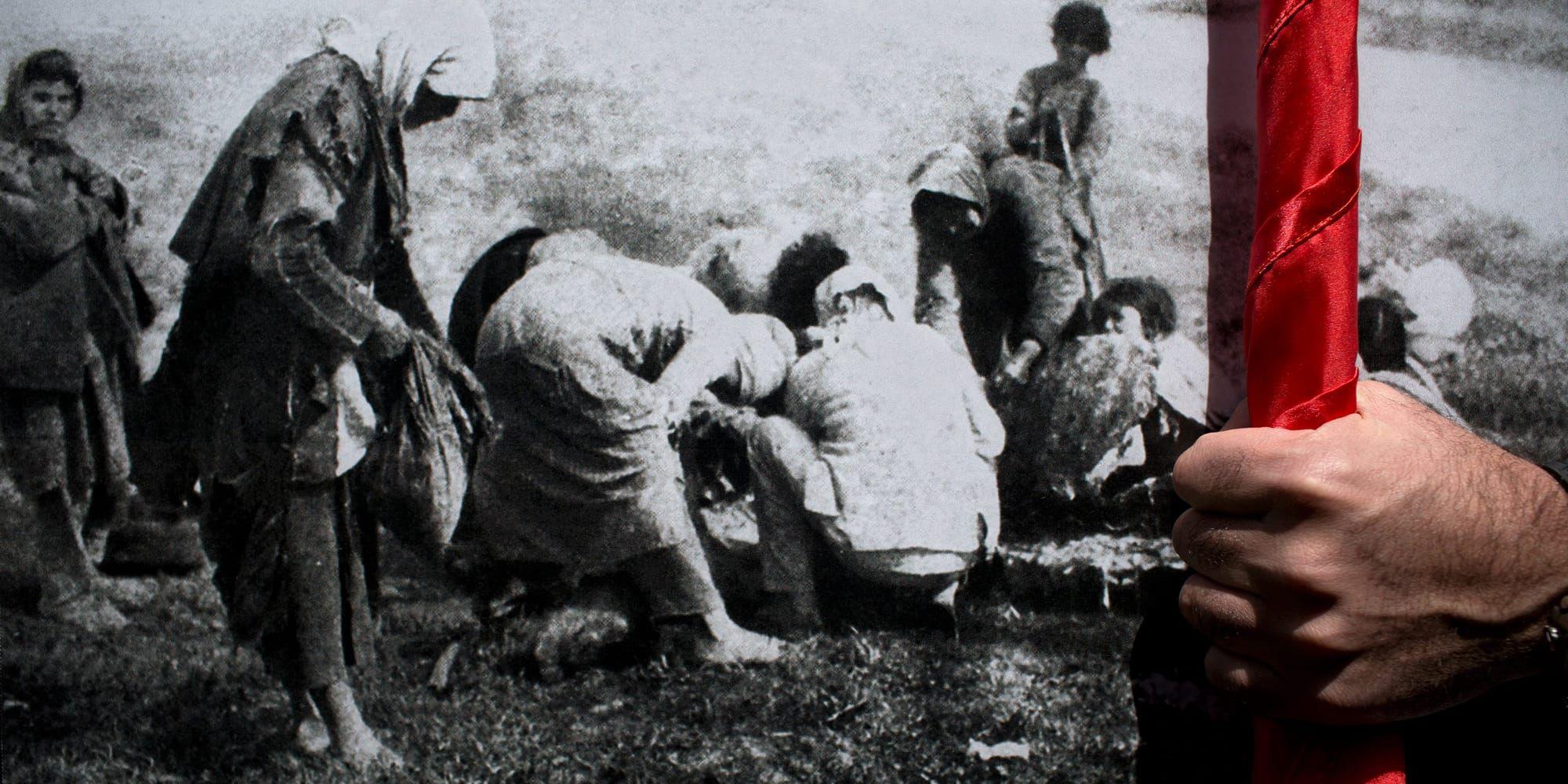 En man håller ett foto från det armeniska folkmordet.