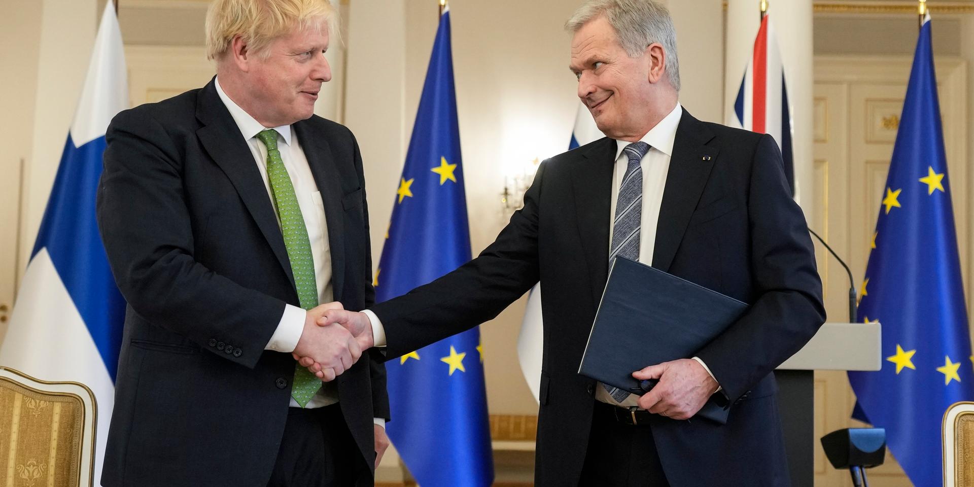 Storbritanniens premiärminister Boris Johnson skakar hand med Finlands president Sauli Niinistö efter undertecknandet av solidaritetsförklaringen mellan länderna.