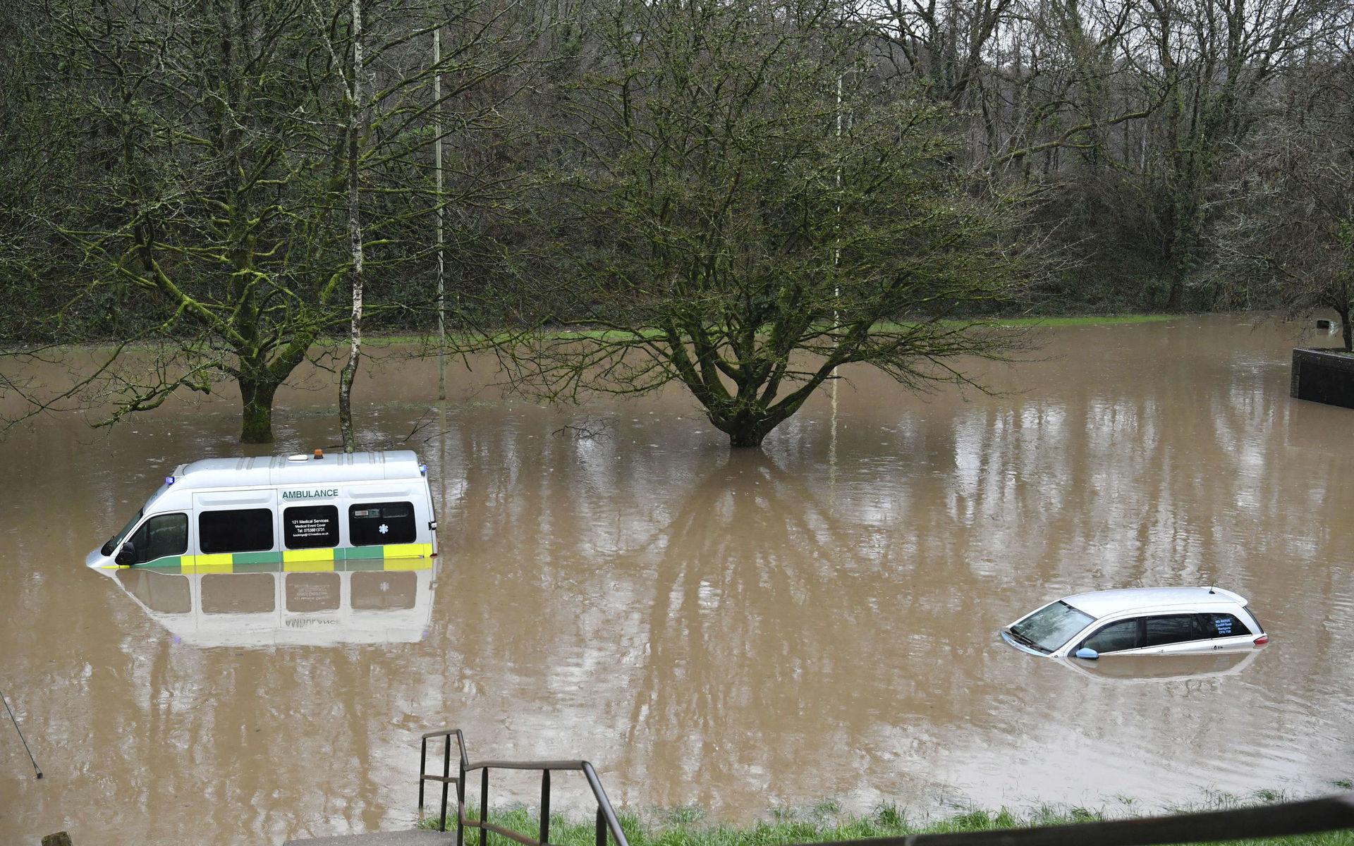 En ambulans och en personbil fast i de kraftiga översvämningar som drabbat Wales.