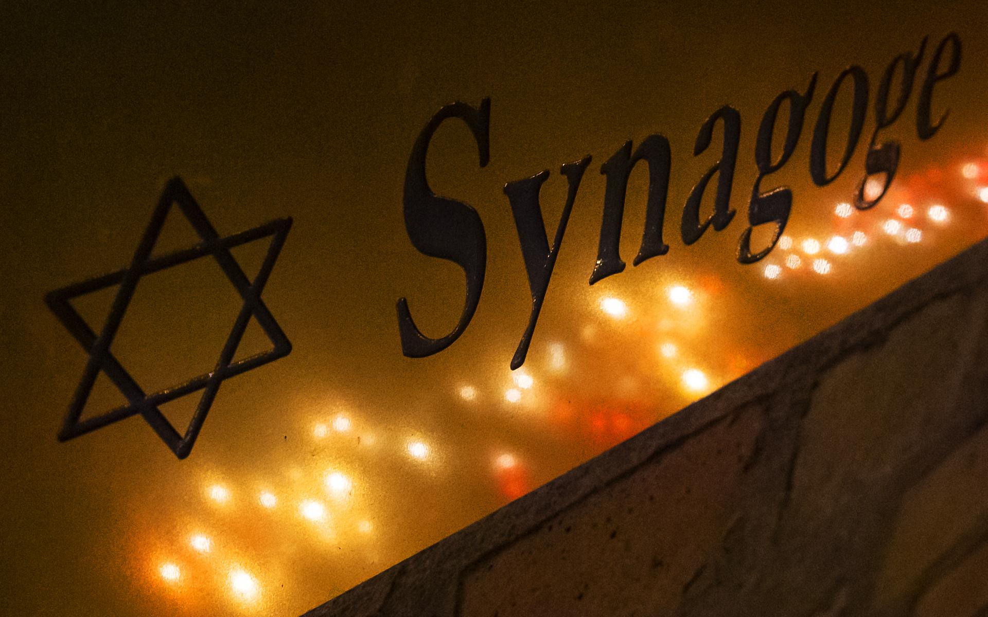 Ljus speglas i en entréskylt utanför synagogan i tyska Halle där en tungt beväpnad man försökt komma in i synagogan under högtiden Yom Kippur. 