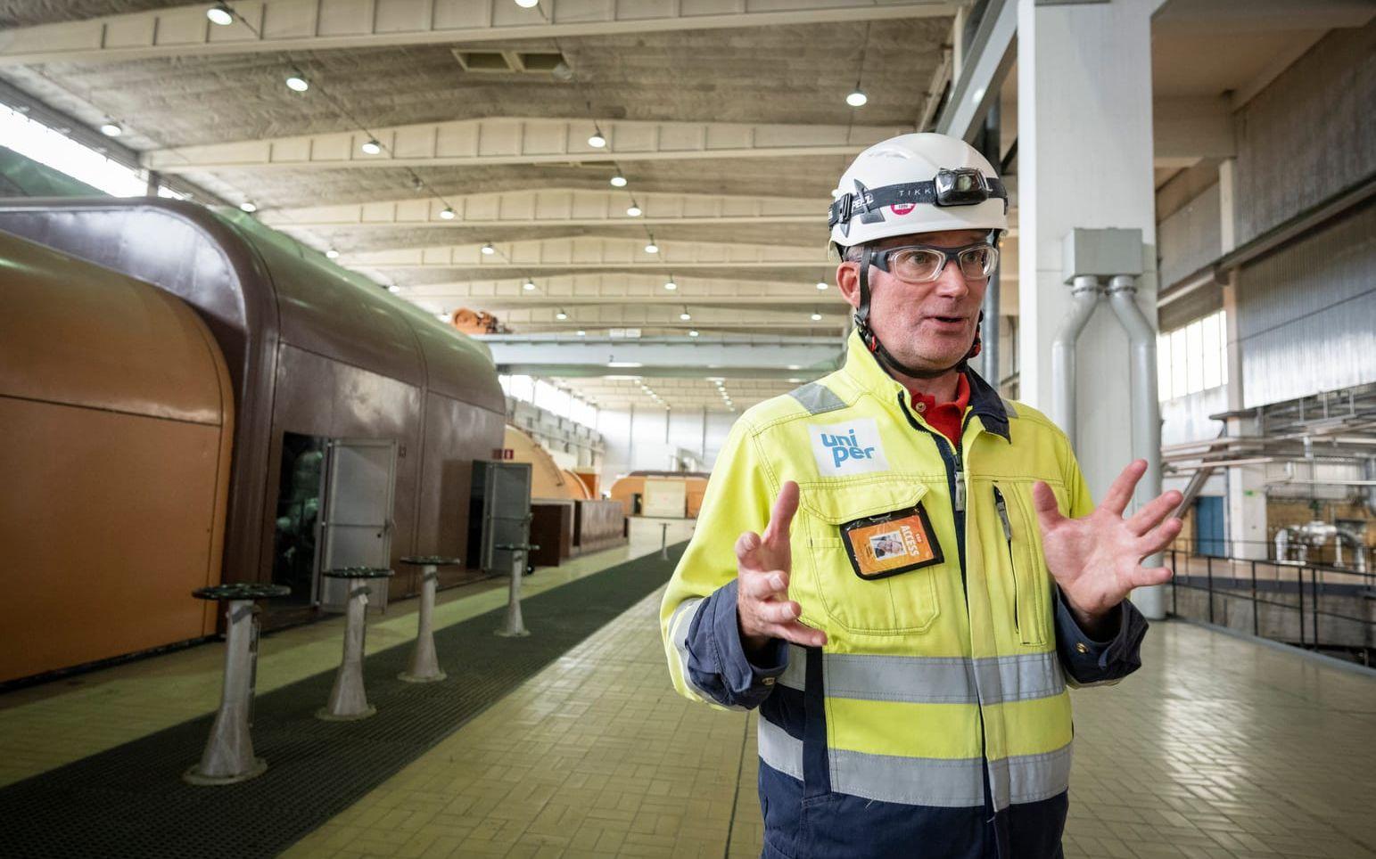 Henrik Svensson, chef på Karlshamnsverket, framför generatorerna i turbinhallen.