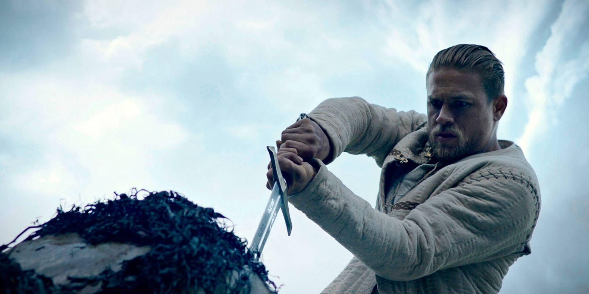 Charlie Hunnam drar ur svärdet ur stenen i "King Arthur: Legend of the sword". Pressbild.
