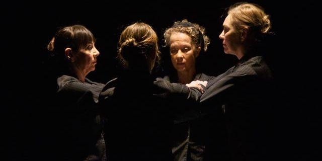 Fyra svartklädda dansare står vända mot varandra i en cirkel.