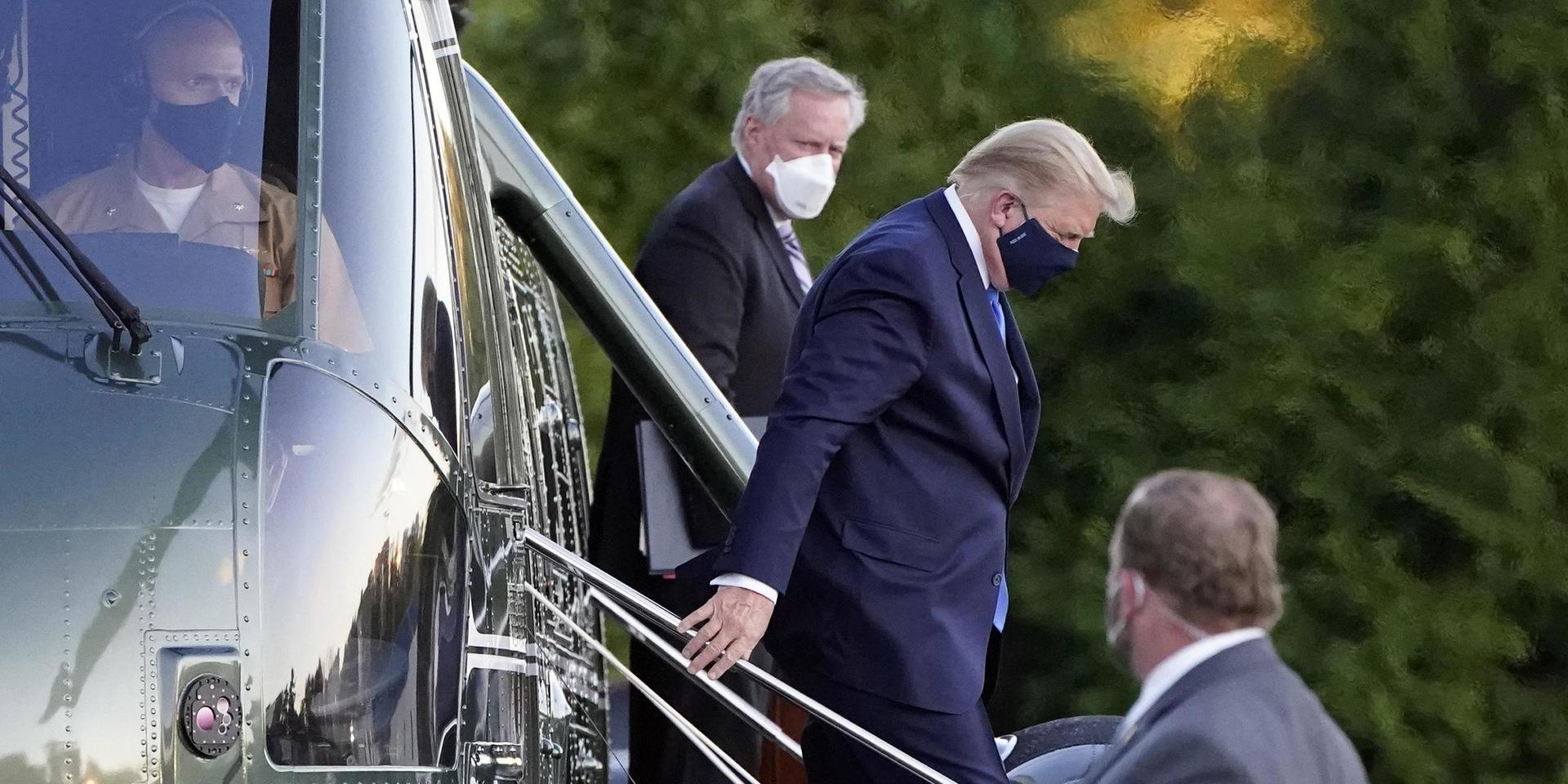 President Donald Trump anlände med helikopter till sjukhuset, en mil från Vita huset på fredagen, iförd munskydd.