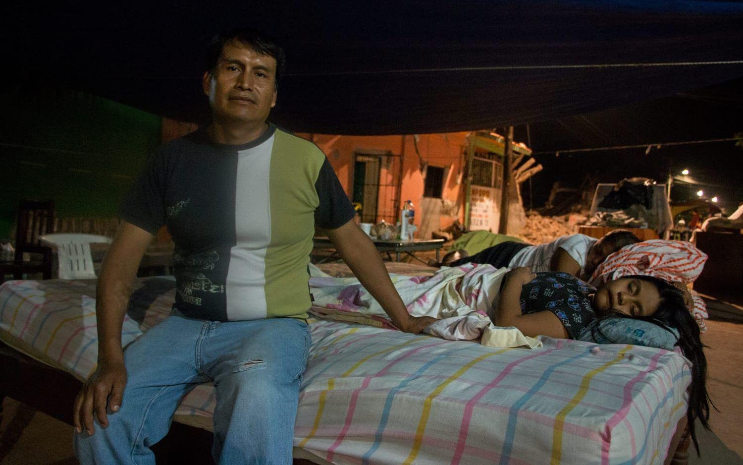 Pedro Arán bor ute på gatan. Dottern Erin Naomi ligger och sover bredvid en granne, i en säng som räddats ur ett av husen. Tillsammans med sin fru bakar och säljer Pedro bröd. Utan hjälp från myndigheterna är chanserna små att de ska lyckas bygga upp sitt hem från grunden igen. Foto: Åsa Welander