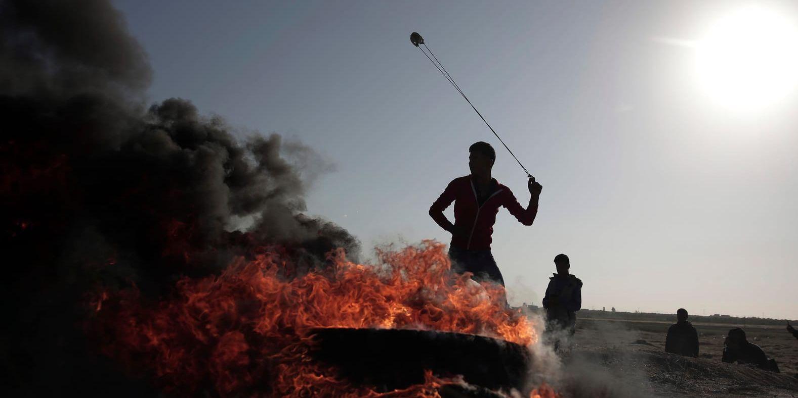 En palestinier använder en stenslunga under lördagens protester.