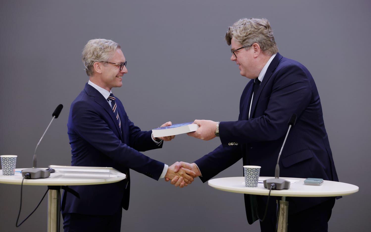 Justitieminister Gunnar Strömmer tar emot biometriutredningen, som är tänkt att effektivisera brottsbekämpning, av utredaren, chefsjuristen Eric Leijonram.